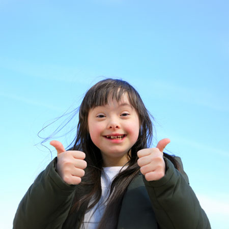 Happy little girl with both thumbs up