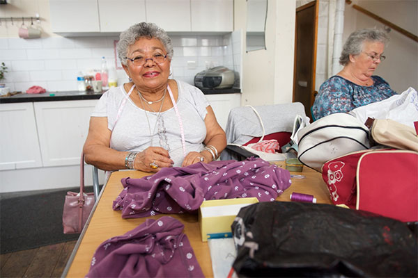 Luisa sewing purple material with another woman next to her